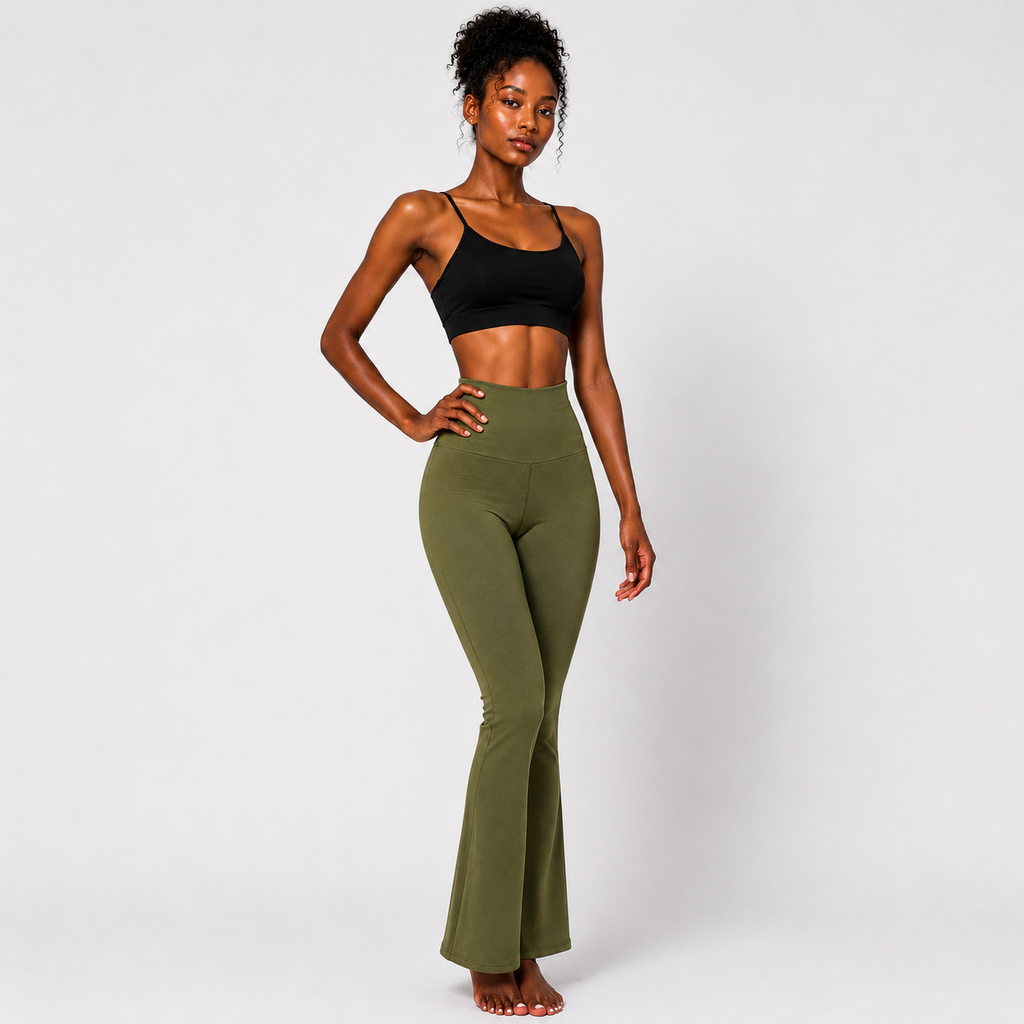 A woman modeling high-waisted olive green flare leggings with a black sports bra against a light gray studio background.